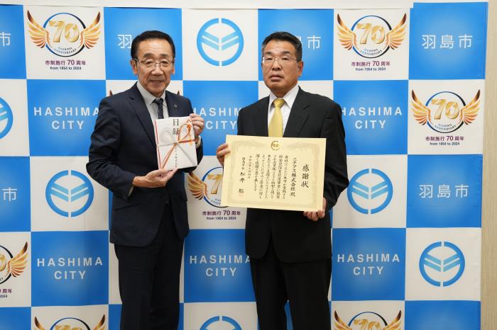 記念撮影する松井市長と滝本工場長